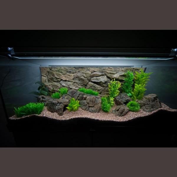 Opstillet akvarium med LED-belysning, kunstige planter og stenbaggrund, perfekt til inspiration hos tildinfisk.dk.